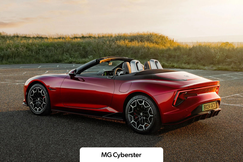 A red MG Cyberster parked with grass in the background