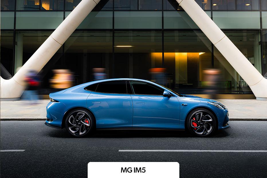 A blue MG IM5 driving through a city