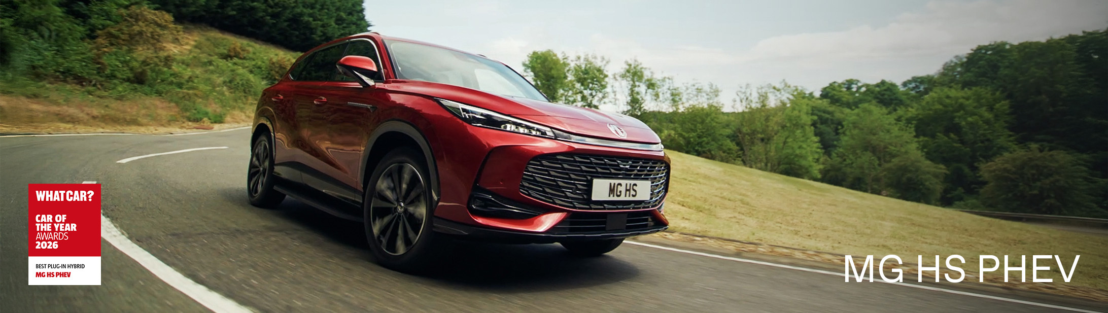 A red MG HS PHEV driving on a country road